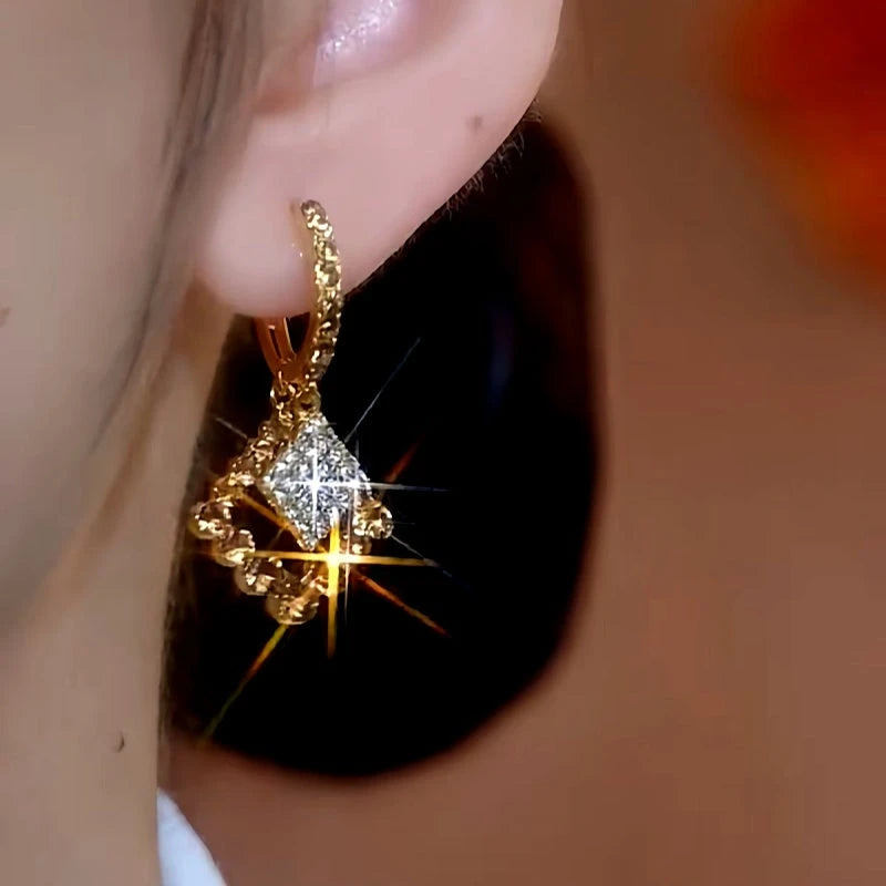 Model showcasing the dangle and style of the 14K Gold-Plated Brown Zircon Diamond Earrings