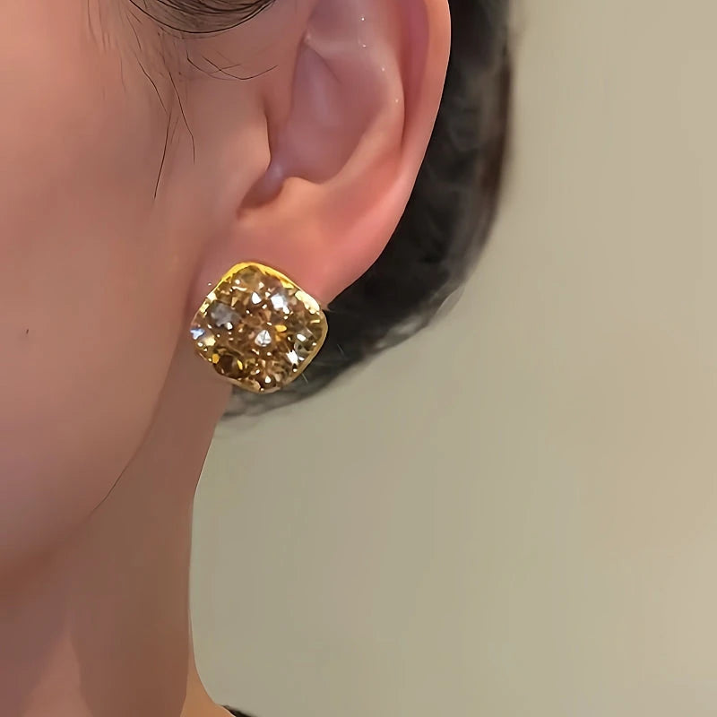 Model showcasing the dangle and style of the 14K Gold-Plated Brown Zircon Diamond Stud Earrings