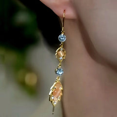 Model showcasing the dangle and style of the 14K Gold-Plated Brown Zircon Double Jade Leaf Threader Tassel Earrings