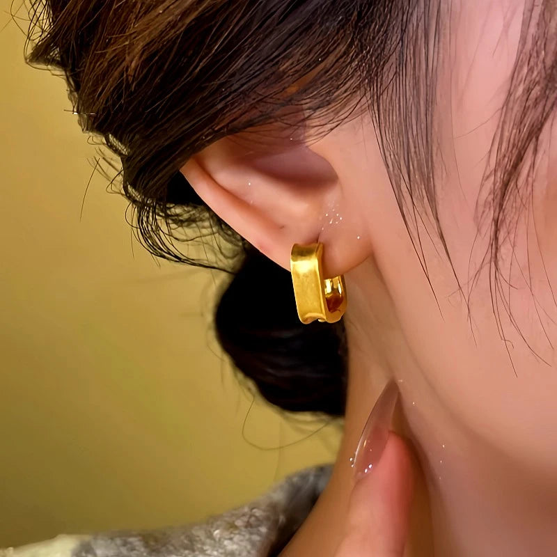 Model showcasing the dangle and style of the 14K Gold-Plated Brushed Earrings