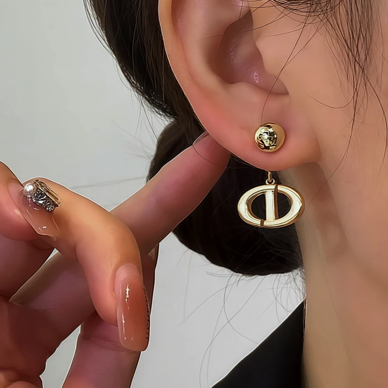 Model showcasing the dangle and style of the 14K Gold-Plated Brushed Letter Earrings