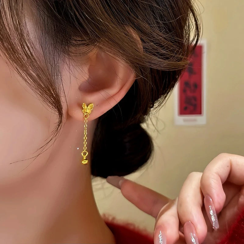 Model showcasing the dangle and style of the 14K Gold-Plated Butterfly Tassel Earrings
