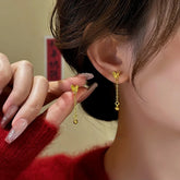 Dainty Gold Butterfly Dangle Earrings with Ball Drop, One Worn, One Held in Hand