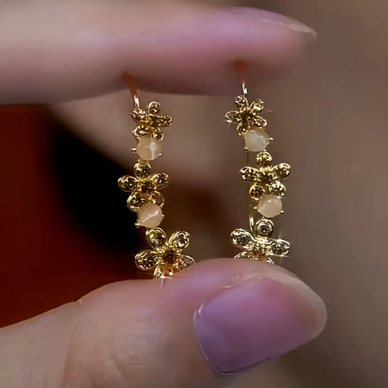 Model showcasing the dangle and style of the 14K Gold-Plated Cat's Eye Brown Zircon Diamond Flower Crawler Earrings