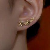 Graduated gold flower ear crawler with cream cat's eye beads on right ear