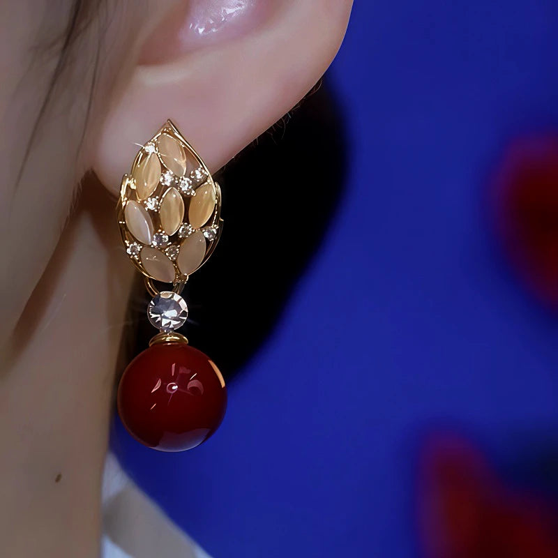 Model showcasing the dangle and style of the 14K Gold-Plated Cat's Eye Leaf Pearl Earrings