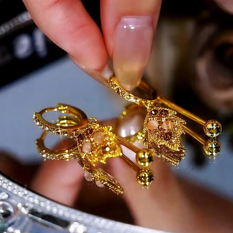 Angled view of the 14K Gold-Plated Cat's Eye Stone Brown Diamond Leaf Earrings