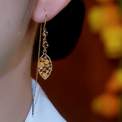 Vintage gold filigree teardrop long chain dangle earring worn on ear