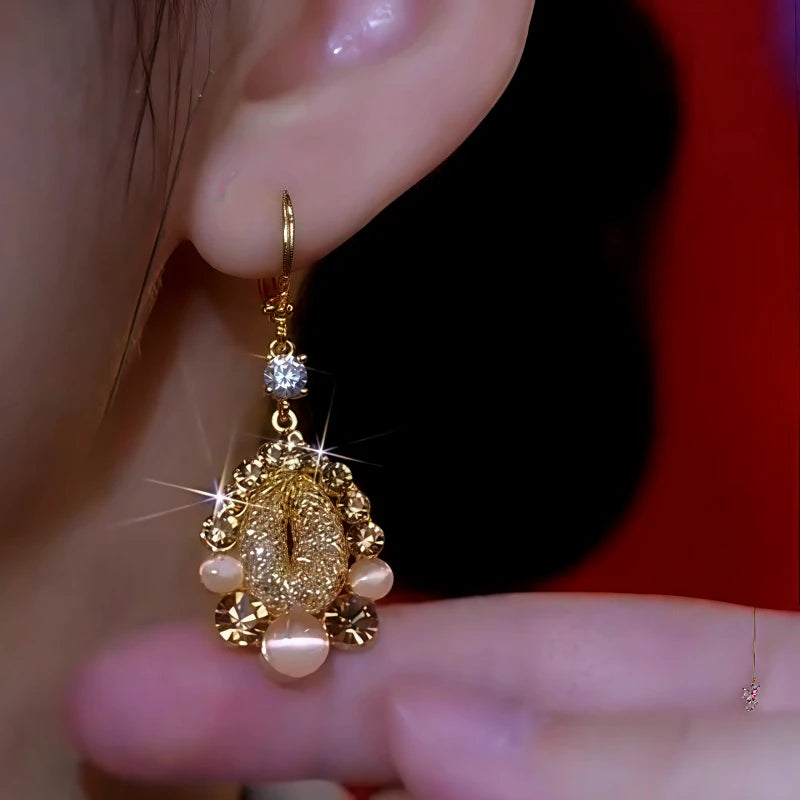 Model showcasing the dangle and style of the 14K Gold-Plated Cat's Eye Stone Brown Diamond Water Drop Earrings