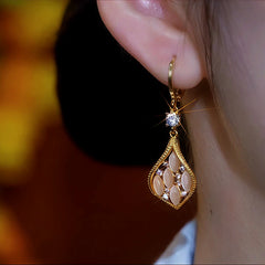 Model showcasing the dangle and style of the 14K Gold-Plated Cat's Eye Stone Diamond Earrings