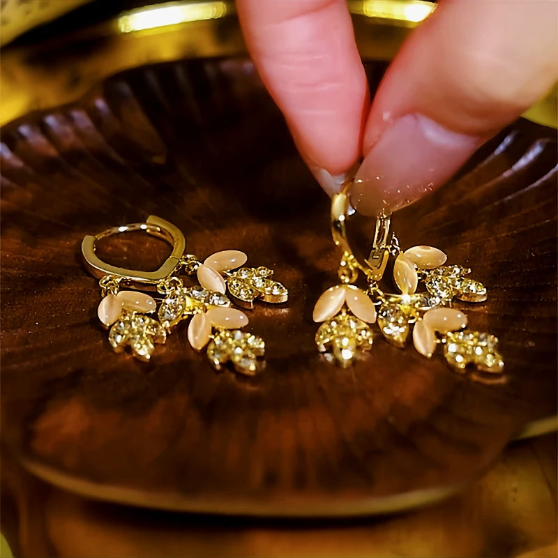 Angled view of the 14K Gold-Plated Cat's Eye Stone Diamond Leaf Tassel Earrings