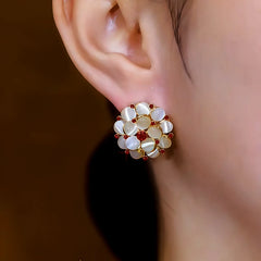 Model showcasing the dangle and style of the 14K Gold-Plated Cat's Eye Stone Flower Stud Earrings