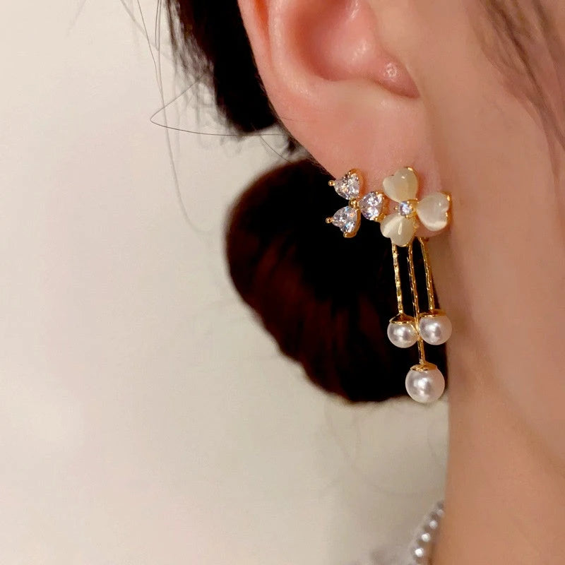 Model showcasing the dangle and style of the 14K Gold-Plated Cat's Eye Stone Flower Tassel Earrings