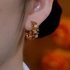 Model showcasing the dangle and style of the 14K Gold-Plated Cat's Eye Stone Full Diamond Hoop Earrings