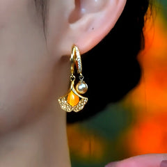 Model showcasing the dangle and style of the 14K Gold-Plated Cat's Eye Stone Ginkgo Leaf Earrings