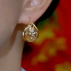 Model showcasing the dangle and style of the 14K Gold-Plated Cat's Eye Stone Oil Drop Water Drop Earrings