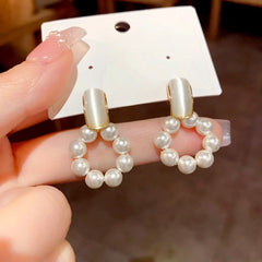 Model showcasing the dangle and style of the 14K Gold-Plated Cat's Eye Stone Pearl Swinging Earrings