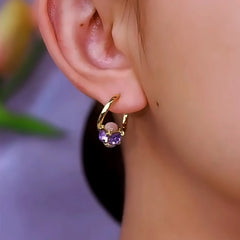 Model showcasing the dangle and style of the 14K Gold-Plated Cat's Eye Stone Purple Diamond Earrings
