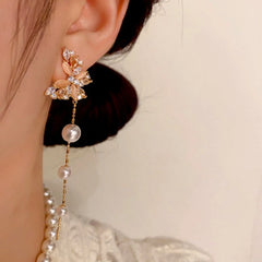 Model showcasing the dangle and style of the 14K Gold-Plated Cat's Eye Stone Zircon Butterfly Pearl Tassel Earrings