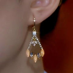 Model showcasing the dangle and style of the 14K Gold-Plated Cat's Eye Zircon Diamond Earrings