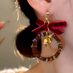 Model showcasing the dangle and style of the 14K Gold-Plated Christmas Hoop Bow Bell Earrings