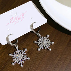 Model showcasing the dangle and style of the 14K Gold-Plated Christmas Pearl Snowflake Earrings