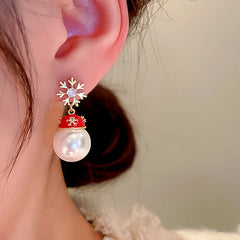 Model showcasing the dangle and style of the 14K Gold-Plated Christmas Zircon Snowflake Hat Imitation Pearl Earrings