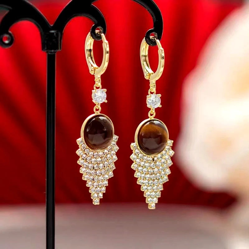 Angled view of the 14K Gold-Plated Classic Brown Water Drop Tassel Earrings