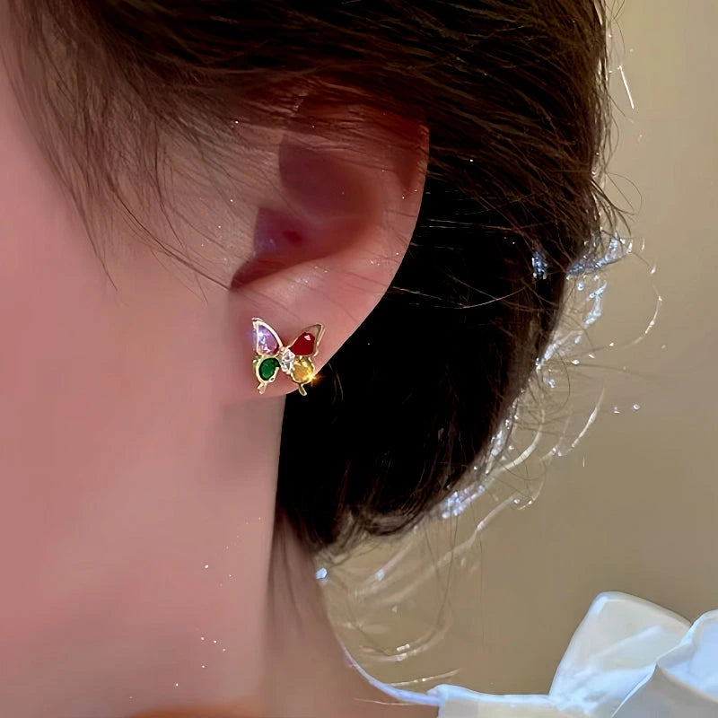 Model showcasing the dangle and style of the 14K Gold-Plated Colorful Butterfly Stud Earrings
