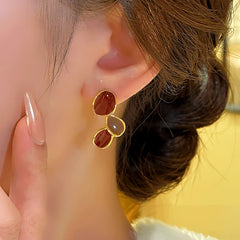 Model showcasing the dangle and style of the 14K Gold-Plated Contrasting Irregular Diamond Earrings
