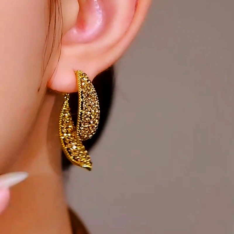 Model showcasing the dangle and style of the 14K Gold-Plated Cross Earrings