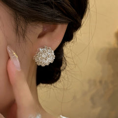 Model showcasing the dangle and style of the 14K Gold-Plated Crystal Flower Stud Earrings