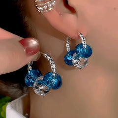 Model showcasing the dangle and style of the 14K Gold-Plated Crystal Hoop Earrings