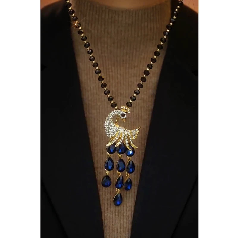 Close-up of the pendant and clasp on the Peacock Sweater Necklace