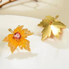 Model showcasing the dangle and style of the 14K Gold-Plated Crystal Zircon Maple Leaf Stud Earrings