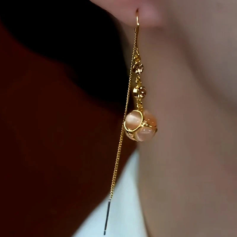 Model showcasing the dangle and style of the 14K Gold-Plated Diamond Cat's Eye Stone Ball Threader Tassel Earrings
