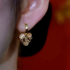 Model showcasing the dangle and style of the 14K Gold-Plated Diamond Cat's Eye Stone Heart Earrings