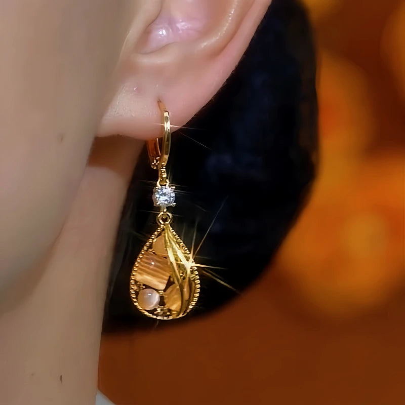 Model showcasing the dangle and style of the 14K Gold-Plated Diamond Cat's Eye Water Drop Earrings
