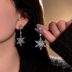 Model showcasing the dangle and style of the 14K Gold-Plated Diamond Christmas Double Snowflake Earrings