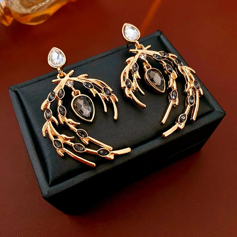 Model showcasing the dangle and style of the 14K Gold-Plated Diamond Feather Earrings