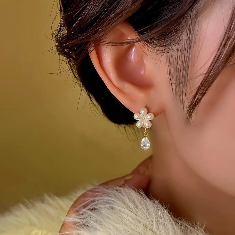 Model showcasing the dangle and style of the 14K Gold-Plated Diamond Flower Earrings