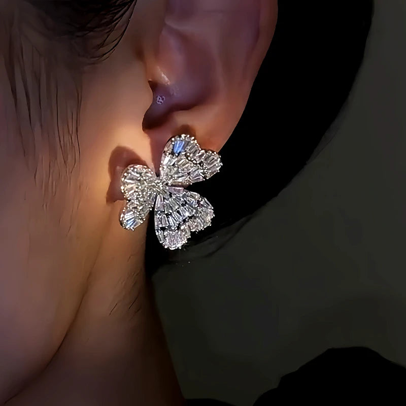 Model showcasing the dangle and style of the 14K Gold-Plated Diamond Flower Earrings