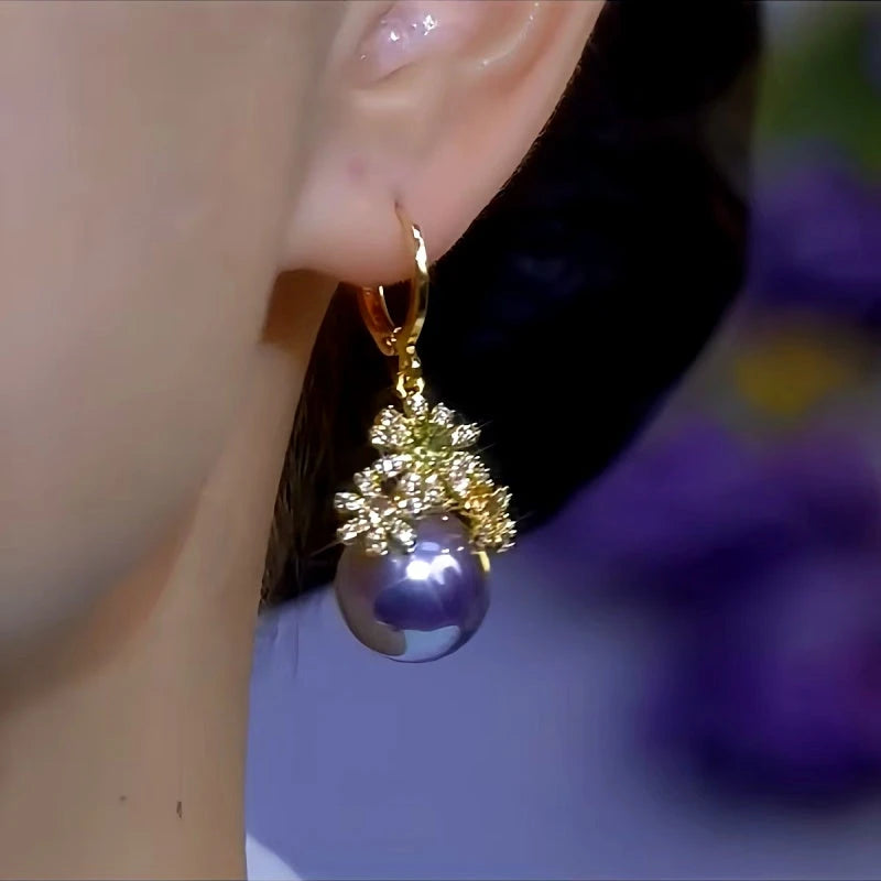 Model showcasing the dangle and style of the 14K Gold-Plated Diamond Flower Purple Pearl Earrings