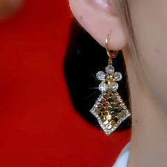 Model showcasing the dangle and style of the 14K Gold-Plated Diamond Flower Sequin Tassel Earrings