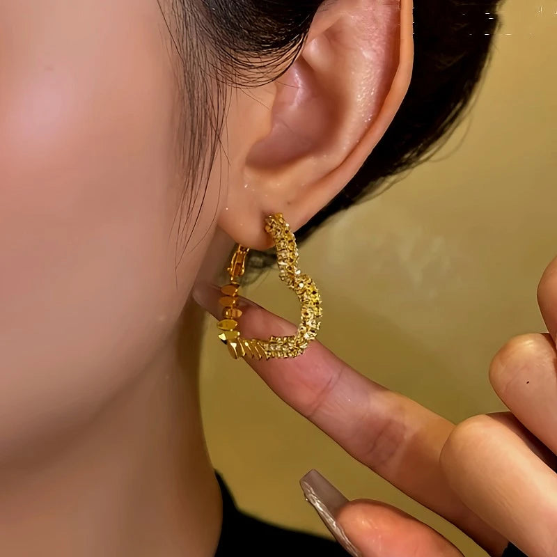 Model showcasing the dangle and style of the 14K Gold-Plated Diamond Heart Earrings