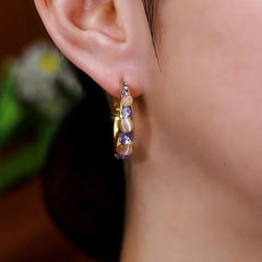 Model showcasing the dangle and style of the 14K Gold-Plated Diamond Hoop Earrings