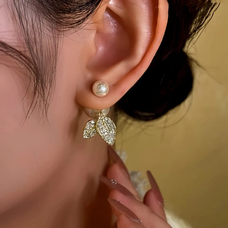 Model showcasing the dangle and style of the 14K Gold-Plated Diamond Leaf Pearl Earrings