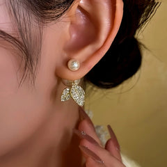 Model showcasing the dangle and style of the 14K Gold-Plated Diamond Leaf Pearl Earrings