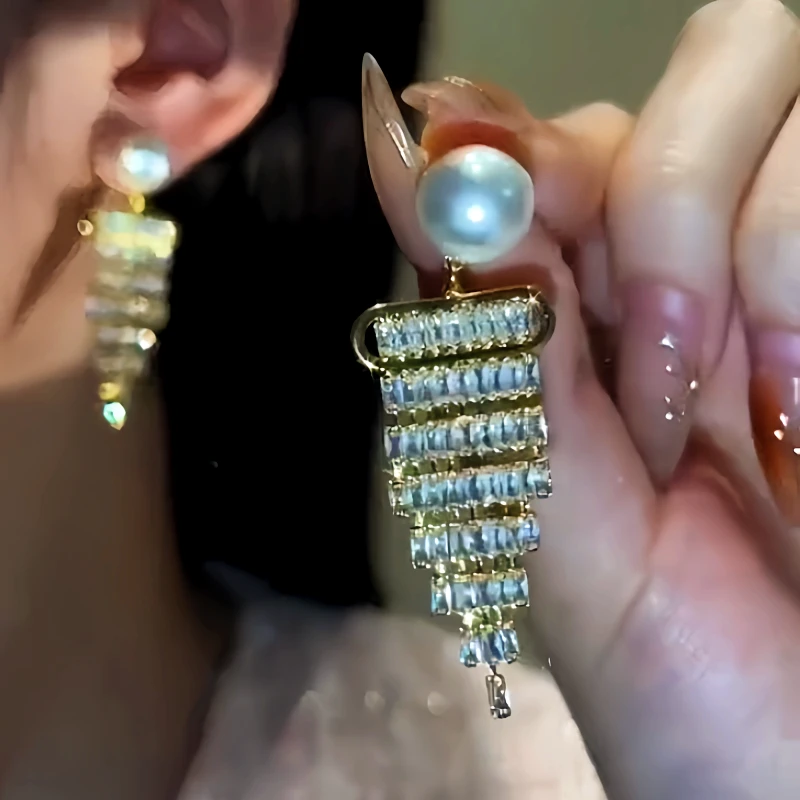 Model showcasing the dangle and style of the 14K Gold-Plated Diamond Pearl Tassel Earrings