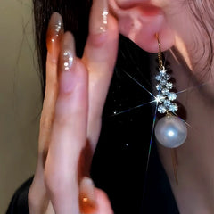 Model showcasing the dangle and style of the 14K Gold-Plated Diamond Pearl Threader Earrings